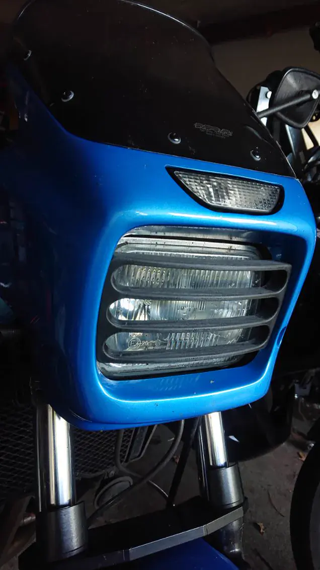 Grille de phare imprimée en 3D, peinte en bleu et montée à l’avant d’une moto