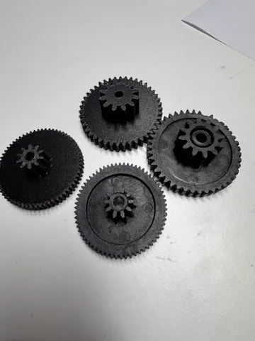 Quatre engrenages noirs imprimés en 3D pour remplacer des pièces d’origine